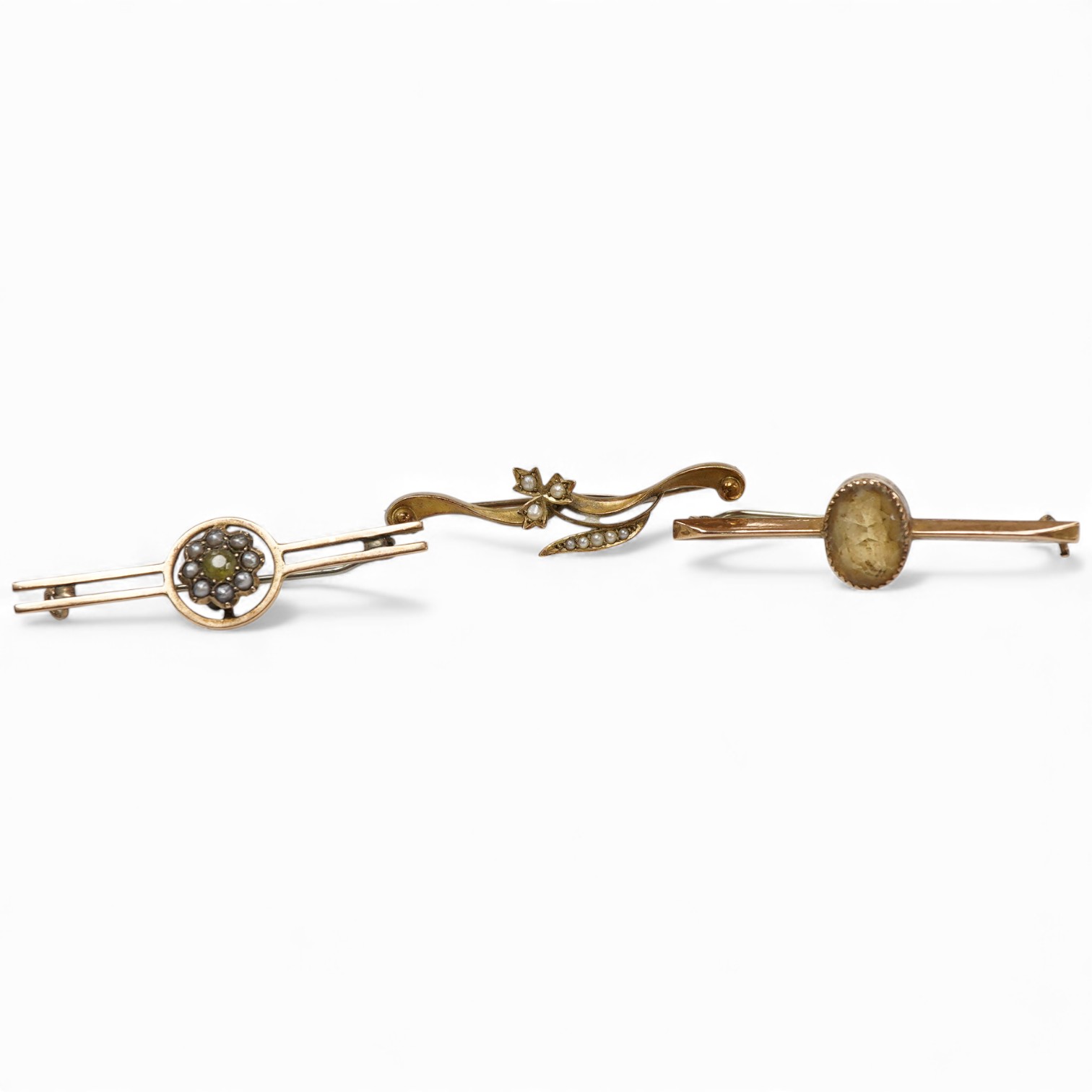 An Edwardian 15ct gold and seed pearl set foliate bar brooch, 41mm, together with a 9ct gold and gem set bar brooch and one other yellow metal and gem set bar brooch.
